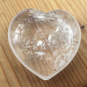clear quartz heart on wooden table