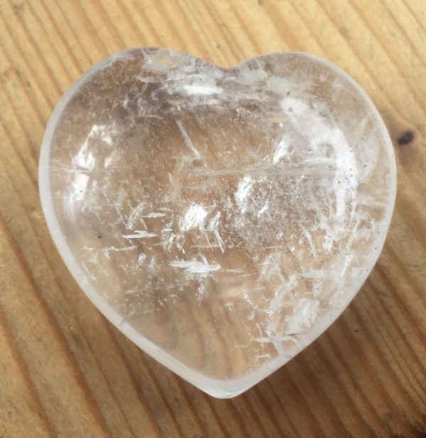 clear quartz heart on wooden table