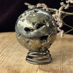 Iron pyrite polished sphere with natural cavities filled with pyrite crystals