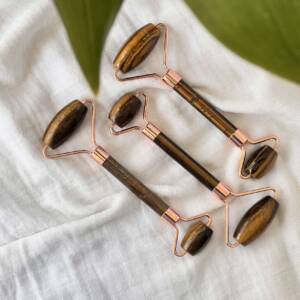 Golden tiger eye massage roller with a 'rose gold' setting