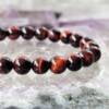 red tiger eye bracelet made with 8 mm round beads threaded on to elastic