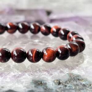 red tiger eye bracelet made with 8 mm round beads threaded on to elastic