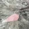 rose quartz pendulum with a white metal chain and ring to hold