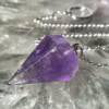 amethyst pendulum, translucent purple, six sided with a white metal chain and ring