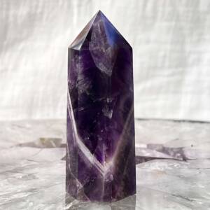 chevron amethyst tower with a white band through the six sided purple crystal