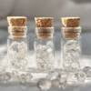 natural herkimer diamonds ten to a clear glass, corked bottle, a double terminated natural form of clear quartz