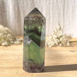 fluorite tower with bright green and purple zigzag bands throughout the six sided cut and polished point