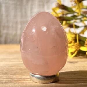 rose quartz yoni egg with a hole drilled to hold a cord which is provided but not shown