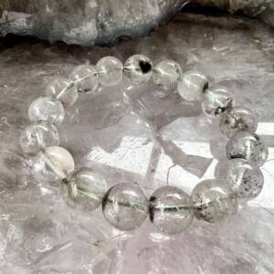 clear quartz bracelet with inclusion in the 12 mm beads threaded with green elastic