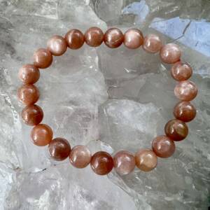 peach moonstone bracelet with a chatoyant play of light typical of feldspar crystal 8mm beads on orange elastic