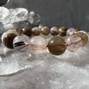 rutilated quartz bracelet made with 11 mm quartz beads each with fine hair like rutile mineral