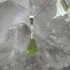 peridot pendant set in silver green gemstone crystal facet cut gem