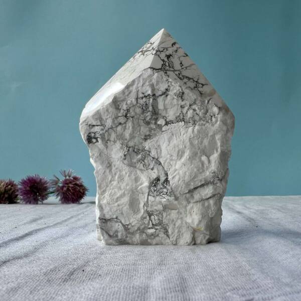 part polished natural howlite six sided point with flat cut base to contrast with the natural white and grey mineral