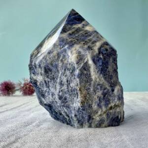 part polished part natural sodalite with a six pointed tip white calcite veining in blue silicate