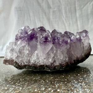 amethyst cluster from Brazil on agate bedrock six sided points ranging from clear quartz to purple quartz with manganese